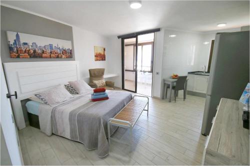 プラヤ・デ・ラス・アメリカスにあるParque Santiago II Studio Tenerife Rental and Salesのベッドルーム1室(ベッド1台、テーブル付)、キッチン