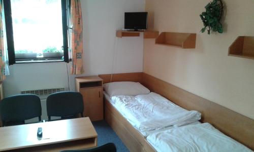 a room with a bed and a desk and chairs at Sportcentrum Dvořák in Hluboká nad Vltavou