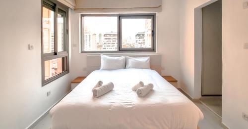a bedroom with a bed with two stuffed animals on it at Spacious Condo in New North by FeelHome in Tel Aviv