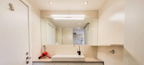 W łazience znajduje się umywalka i lustro. w obiekcie Spacious Condo in New North by FeelHome w Tel Awiwie