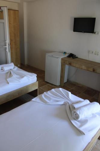 a room with two beds with towels on the floor at GÖKÇEADA BATIHAN OTEL in Bademli