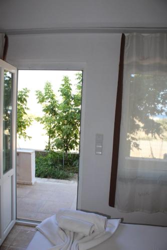 a white room with a window and a bed at GÖKÇEADA BATIHAN OTEL in Bademli