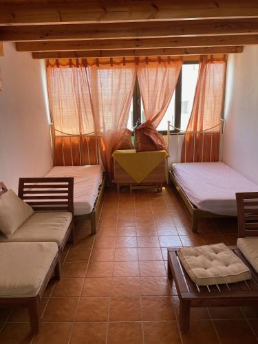 a room with three beds and a couch and a table at Casa Natalie in El Cotillo