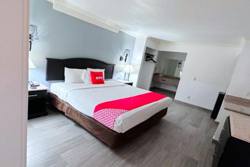 1 dormitorio con 1 cama grande con manta roja en OYO Hotel Three Rivers TX US-281, en Three Rivers