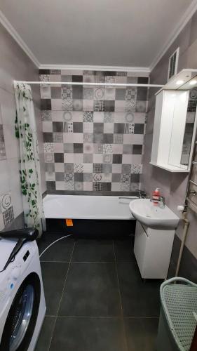 La salle de bains est pourvue d'un lavabo et d'un lave-linge. dans l'établissement 2 кімнатна квартира з 4 окремими ліжками і кондиціонером Документи для відряджень Мережа AlexApartments Безконтактне заселення 24-7, à Poltava