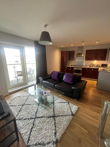 a living room with a couch and a glass table at Quayside Apartments by Urban Space in Cardiff