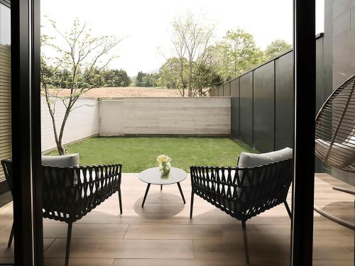 a patio with two chairs and a table and a yard at ANA InterContinental Appi Kogen Resort by IHG in Hachimantai