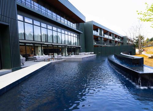 a building with a pond in front of a building at ANA InterContinental Appi Kogen Resort by IHG in Hachimantai