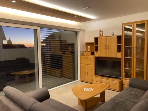 a living room with a couch and a tv at Ferienwohnung Haus Maria in Wäschenbeuren