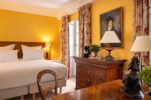 1 dormitorio con 1 cama y 1 mesa con lámpara en Hotel Le Saint Gregoire en París