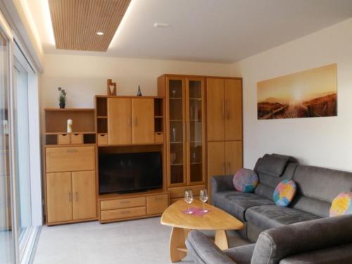 a living room with a couch and a tv at Ferienwohnung Haus Maria in Wäschenbeuren