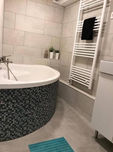 a bathroom with a bath tub and a mirror at Csengery Apartment in Budapest