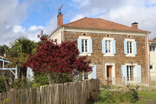 an old brick house with a wooden fence at La Pinède du Chéou in Mimizan