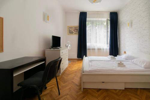 a bedroom with a bed and a desk with a computer at Wondrous Apartment Warszawska street in Krakow