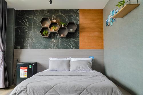 a bedroom with a bed and two shelves on the wall at Cherry Hotel Bến Lức in Bến Lức