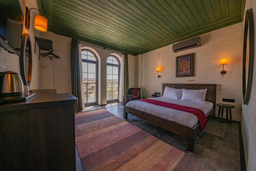 a bedroom with a bed in a room with windows at Perla Cappadocia in Goreme
