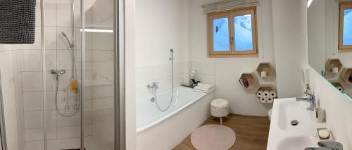 ein Bad mit einer Badewanne, einer Dusche und einem Waschbecken in der Unterkunft Le Lézard et la Grenouille BnB in Ovronnaz
