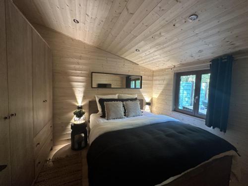 um quarto com uma cama grande num quarto de madeira em Le chalet du lys avec bain scandinave Insolys em Gouvieux