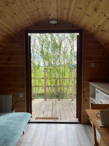 a kitchen with a large door leading to a deck at Wind In The Willows Luxury Glamping in Peterborough