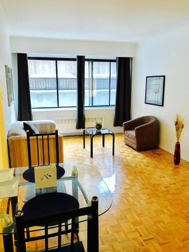 蒙特婁的住宿－Stylish Montreal Apartment: Comfortable Stay in the Golden Square Mile，客厅配有玻璃桌和沙发