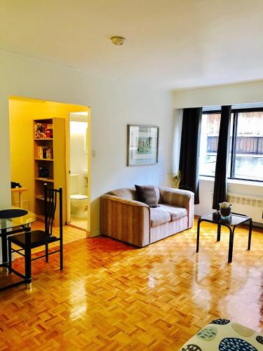 蒙特婁的住宿－Stylish Montreal Apartment: Comfortable Stay in the Golden Square Mile，客厅配有沙发和桌子