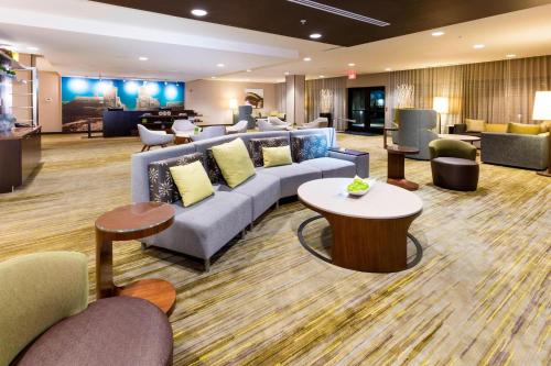 a hotel lobby with a couch and chairs and tables at Courtyard by Marriott St. Augustine Beach in Saint Augustine Beach