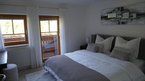 a bedroom with a large bed and two windows at Apartment Bachweg in Forstau