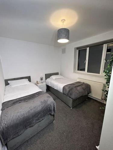 a bedroom with two beds and a window at Whole Apartment Near to London in Bromley