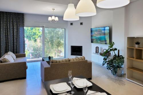 a living room with a couch and a table at Crete Apart House - North in Ayía Marína