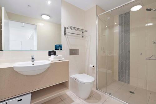 a bathroom with a shower and a toilet and a sink at Romantic Getaway in Surfers Paradise - Elston Apartment with Ocean View - Wow Stay in Gold Coast