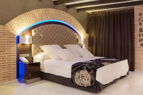 a bedroom with a large bed with an arch above it at Pintor El Greco in Toledo