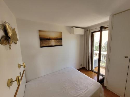 a bedroom with a bed with a picture on the wall at APPARTEMENT VUE MER 200 M DES PLAGES - DJUMBO in Sainte-Maxime