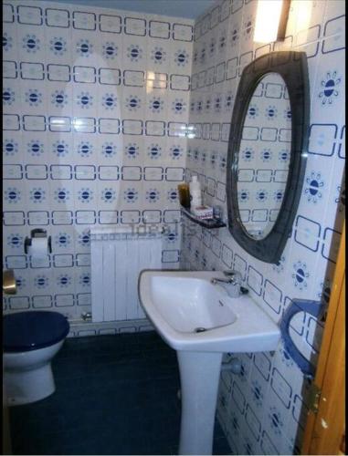a bathroom with a sink and a mirror and a toilet at Apartamento con espectacular terraza in Escarrilla