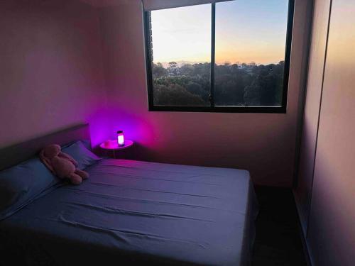 a bedroom with a bed with a teddy bear and a window at Imagine house in Sydney