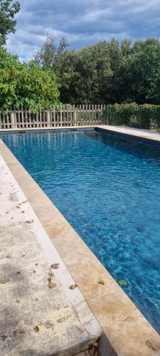 une piscine d'eau bleue et une clôture en bois dans l'établissement La Figalie, à Saint Jean du Pin
