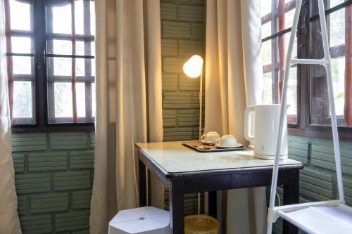 uma pequena mesa num quarto com duas janelas em Breeze Bungalows em Ko Lanta
