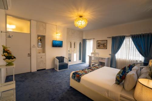 a hotel room with a large bed and a chandelier at Shinepukur Suites at Concord in Dhaka