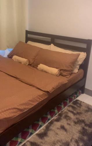 uma cama com duas almofadas num quarto em LJ'S ESCAPE @COAST RESIDENCES em Manila