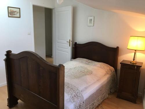 une chambre avec un lit et une lampe sur une table dans l'établissement Classé 2 étoiles - 3 chambres - Appartement Douillet au bord du Quai De Londres dans le cœur de la ville de VERDUN - Géré par Presta-Zen'Services, à Verdun-sur-Meuse