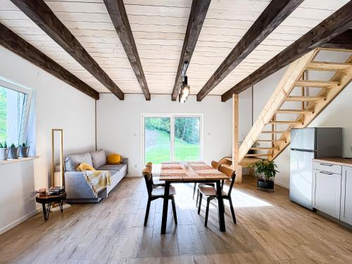 a kitchen and living room with a table and chairs at ZaBieszczaduj - apartamenty do wynajęcia in Lutowiska
