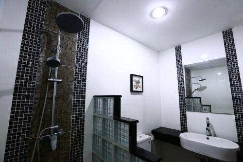 uma casa de banho com um lavatório e um chuveiro em The Pattaya Sports Hub em Pattaya Central