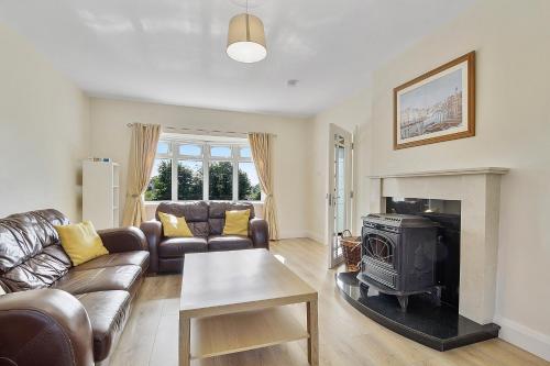a living room with a couch and a stove at Ardmore Cottage - Failte Ireland Quality Assured in Muff