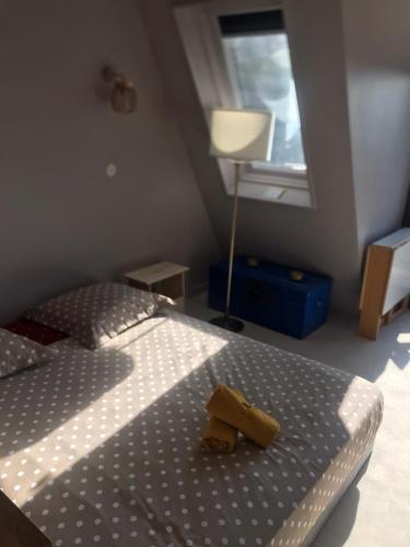 une chambre avec un lit, une lampe et une fenêtre dans l'établissement Le nid sur la mer, à Deauville