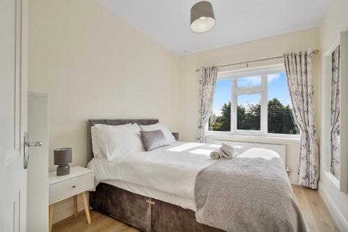 a bedroom with a large bed and a window at Ardmore Cottage - Failte Ireland Quality Assured in Muff