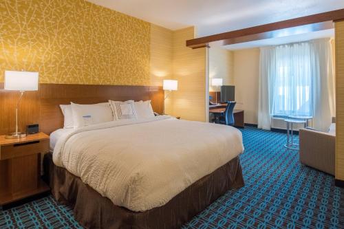 ein Hotelzimmer mit einem großen Bett und einem Schreibtisch in der Unterkunft Fairfield Inn & Suites by Marriott Provo Orem in Orem
