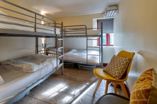 a room with two bunk beds and a chair at Howgills Barn in Sedbergh