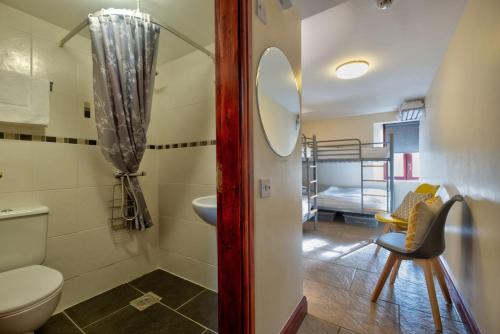a bathroom with a toilet and a sink and a bed at Howgills Barn in Sedbergh
