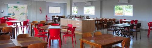 a restaurant with wooden tables and red chairs and tables at Casa Jardins da Lagoa in Caldas Novas