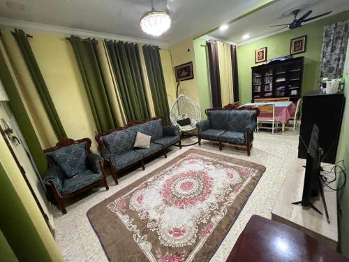 a living room with couches and a rug at DZ’S Homestay in Machang