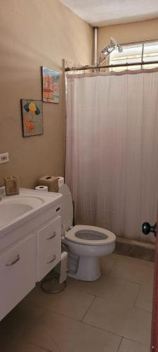a bathroom with a toilet and a shower curtain at Casa LOLO on hills of Culebra in Culebra